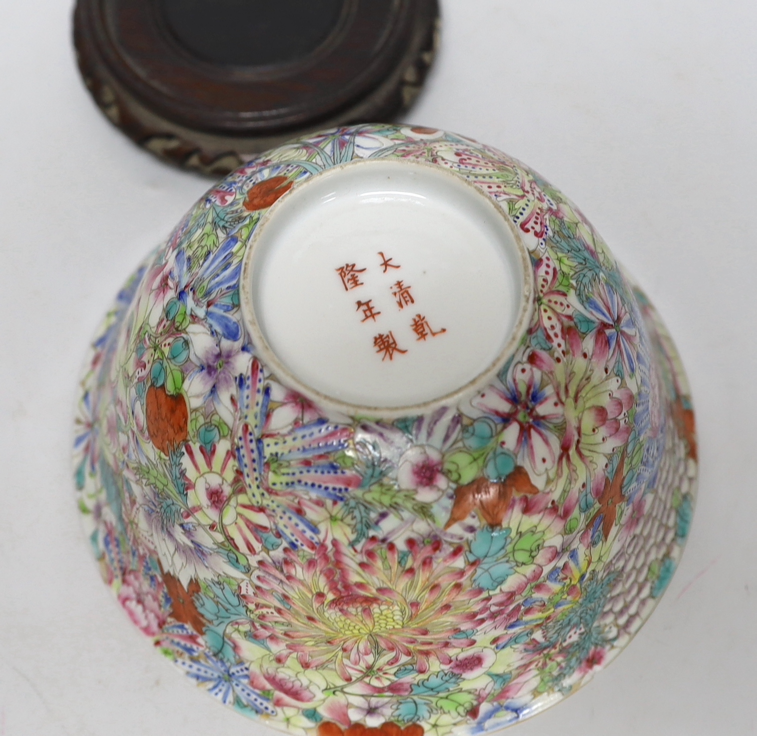 A Chinese 'Thousand Flower' enamelled porcelain bowl, Qianlong mark, early 20th century on hardwood stand, 17cm high